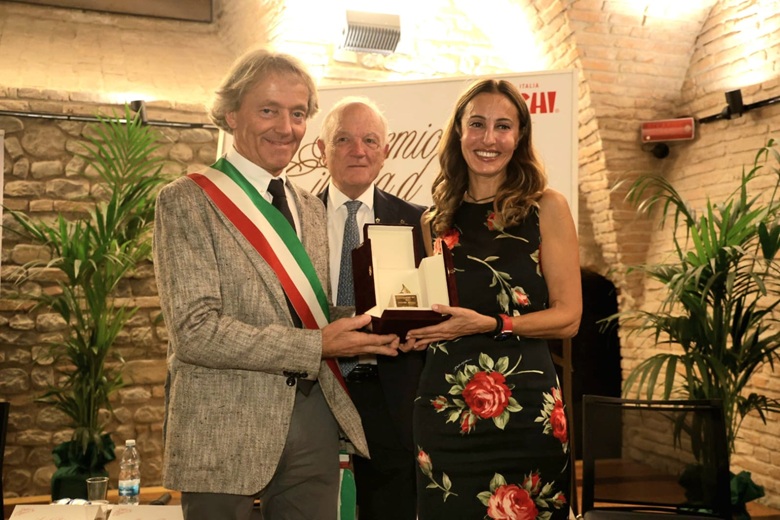Il sindaco di Vignola, Angelo Pasini, e il presidente del Centro Studi Vignola, Massimo Toschi, consegnano il Premio Ciliegia d’Oro 2025 a Federica Minozzi 